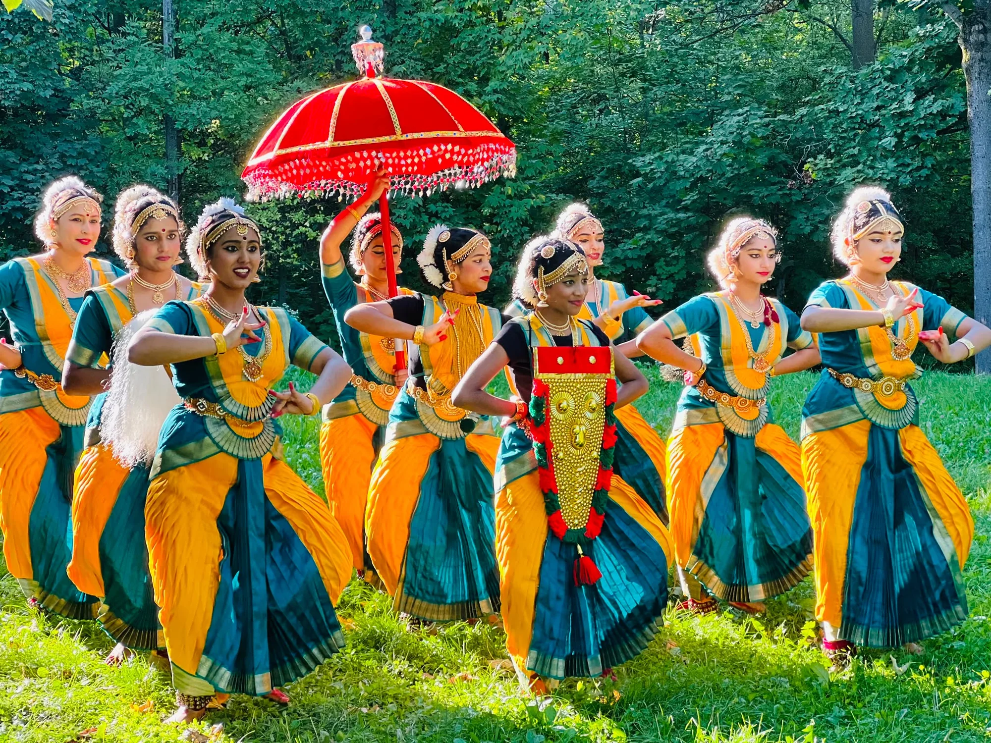 Dancers gathered beneath a ceremonial parasol